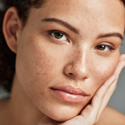 Portrait, beauty skincare and face of woman in studio isolated on gray background. Makeup, natural cosmetics and young female model with glowing, healthy and flawless skin after spa facial treatment.